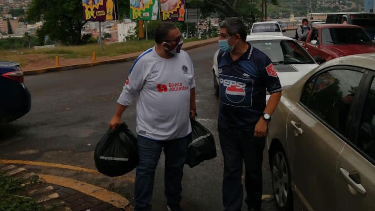 La historia de la foto viral de dos aficionados hondureños juntos para ayudar a los damnificados por Eta