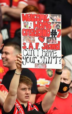 Aficionados del ManU con pancartas en el Old Trafford