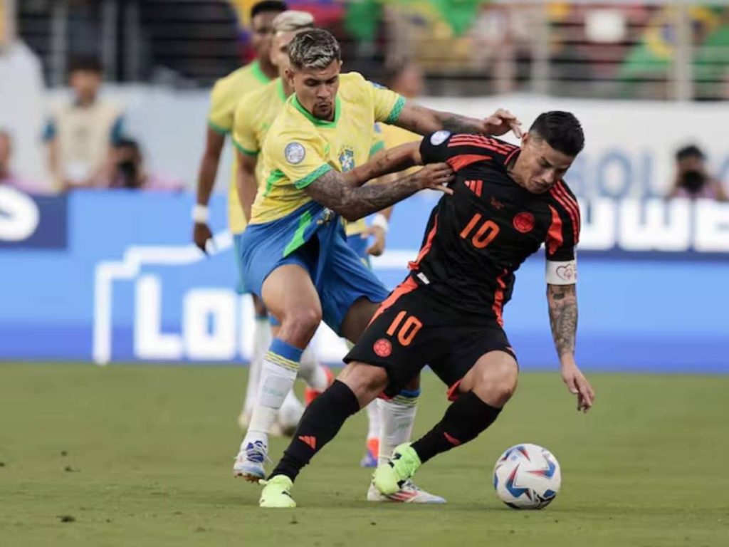 Jugador Brasileño disputando fuerte un balón ante jugador Colobiano.