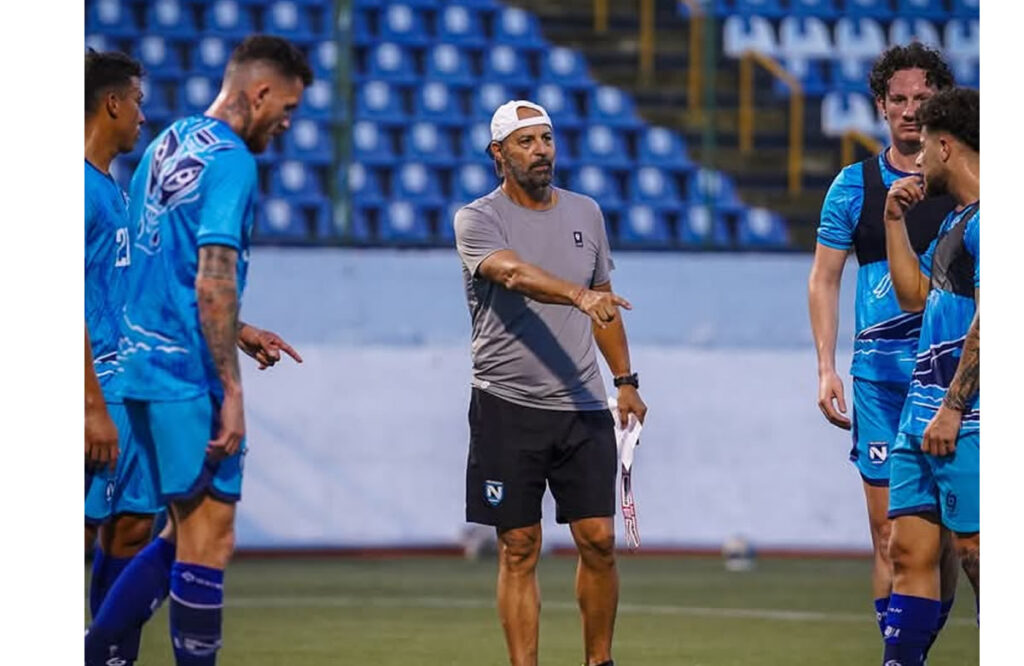 Entrenador de Nicaragua dando instrucciones a sus jugadores y ellos prestándo atención