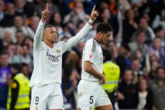 Kylian Mbappe levantando sus manos junto y al lado Jude Bellingham 
