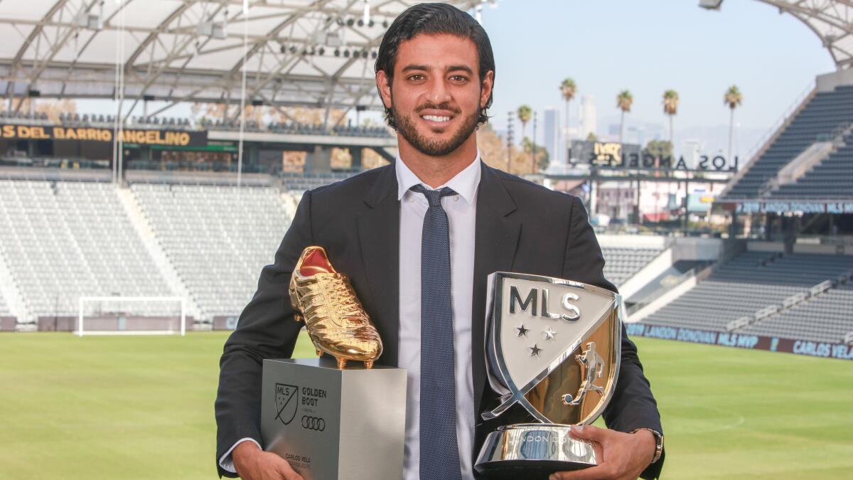 Carlos Vela posando con la bota y premio a jugador del año de la MLS