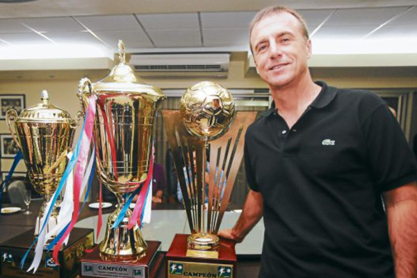 Danillo Tosello posando con los tres trofeos que gano con el Olimpia en Liga Nacional