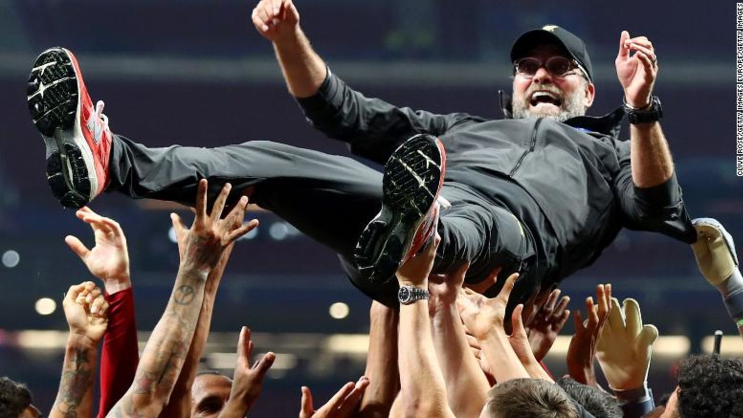 Jurgen Klopp en el aire mientras los jugadores lo tiran celebrando