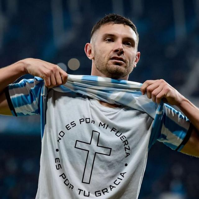 Adrián Martínez enseñando una camisa en dónde le da gracias a Dios